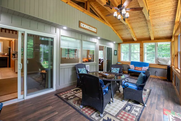 A cozy room with a dining table, chairs, a sofa, and a ceiling fan