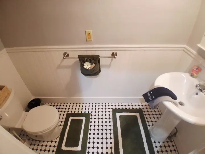A bathroom with a toilet, sink, and a towel rack with a towel