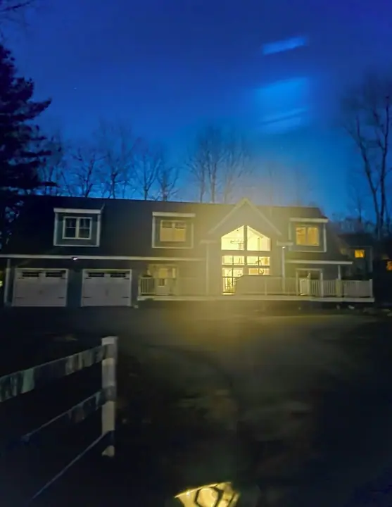 A two-story house with a garage, a front porch, and a driveway