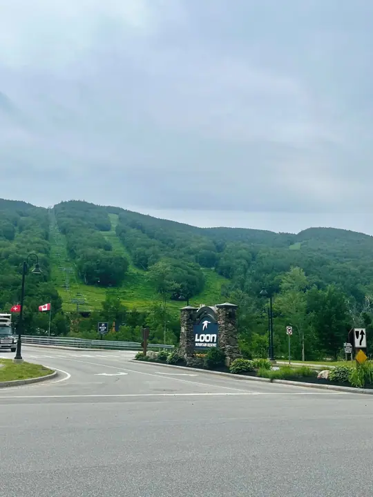 A road leading to Loon Mountain Resort with a sign indicating a parking area