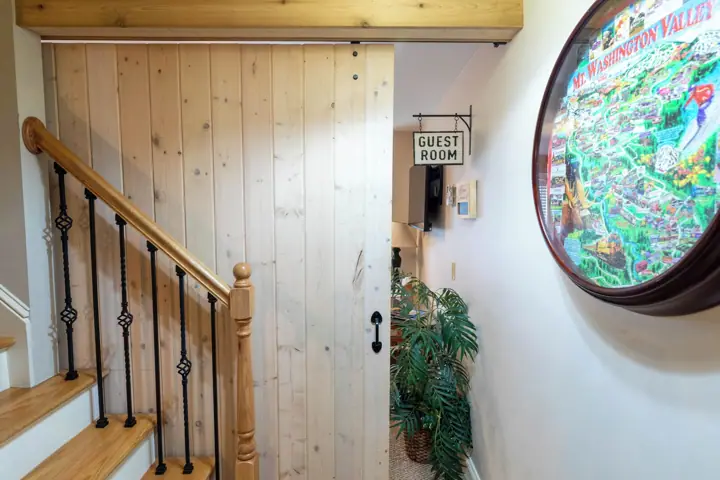 Guest room behind barn door stairs going up to main floor