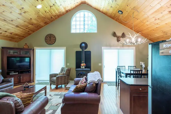 A cozy living room with a fireplace, leather furniture, and a dining area with a table and chairs