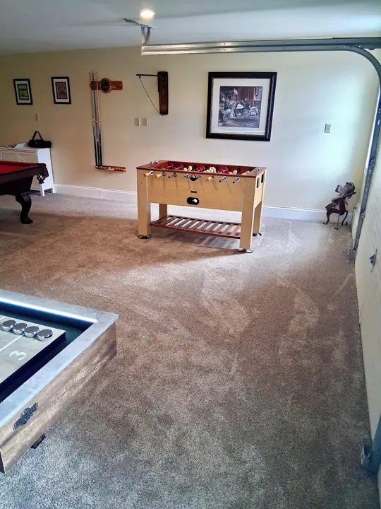 A room with a foosball table, a pool table, and a billiards table