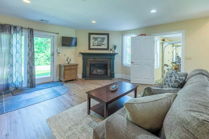 A living room with a fireplace, a sofa, a coffee table, and a television