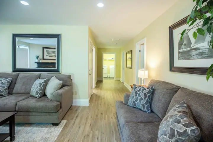 A living room with two grey sofas, a coffee table, and a mirror on the wall