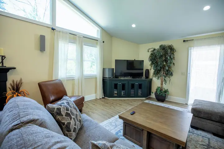 A living room with a sofa, a coffee table, a TV, and a plant